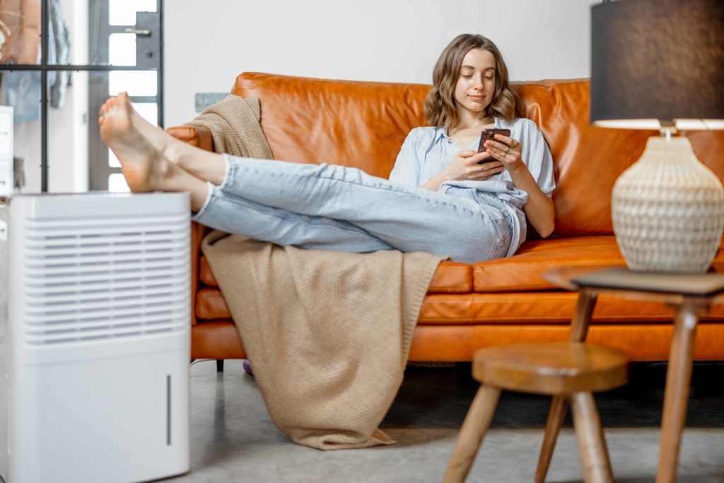 Woman relaxing with feet on air purifier