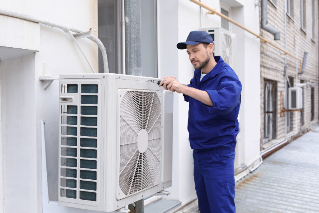 Professional HVAC inspection technician repairing air conditioner outdoors