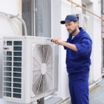 Professional HVAC inspection technician repairing air conditioner outdoors
