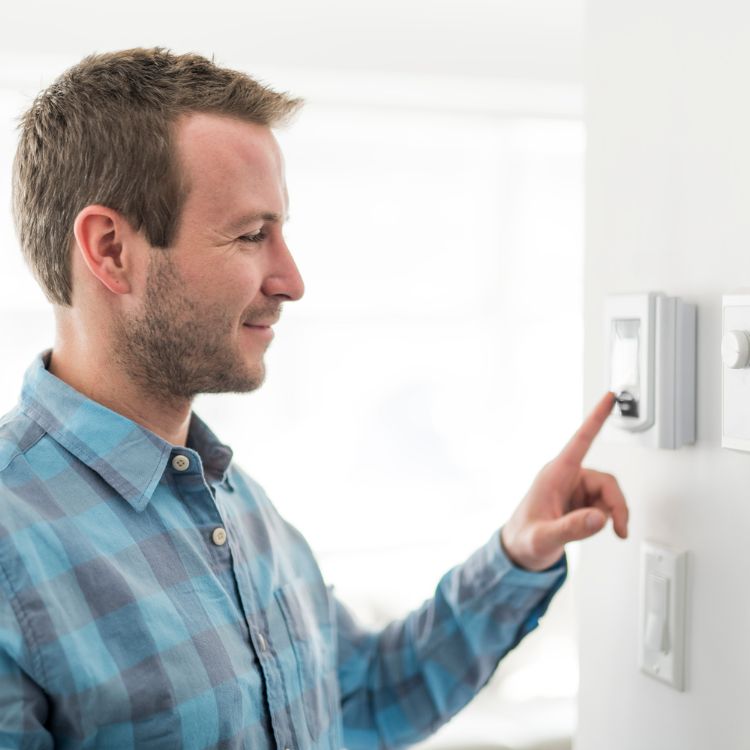 Photo of man checking his thermostat