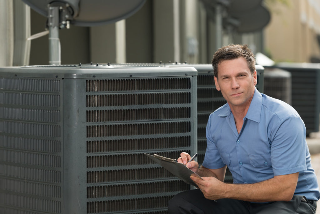 Photo of thirtyish air conditioning repairman with clipboard