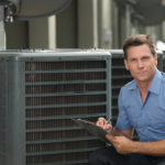 Photo of thirtyish air conditioning repairman with clipboard