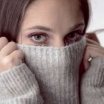 photo of woman hiding face under sweater concerned how to heat home