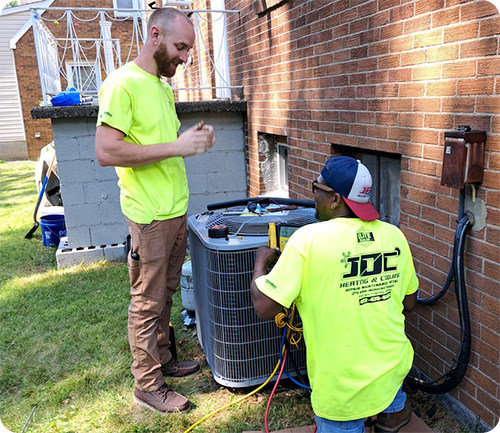 JDC Heating & Cooling HVAC contractors finishing up an AC unit replacement